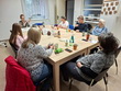 20.04.2026 - Na fotografii probíhá beseda spojená s ochutnávkou čajů a olejnatých semínek. Klienti společně sedí u stolu, sdílejí své dojmy a v příjemné atmosféře si vychutnávají připravené ochutnávky. Zleva: p. Šopová, sl. Šárka (praktikantka), ředitelka p. Mgr. Bělovová Dolejší, p. Voráčková, p. Limberk, p. Limberková, p. Dolejší