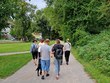 Na fotografii zachycena skupina lidí. Zleva: p. Neckářová, p. Parkosová, DiS., p. Limberk, p. Špinarová, DiS., p. Limberková, ředitelka p. Mgr. Bělovová Dolejší. Skupinka jde po široké zpevněné cestě v parku. Kolem jsou zelené trávníky a husté stromy a keře. V pozadí jsou vidět domy. Nad parkem je modrá obloha s několika mraky