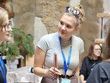 Na fotografii zachycena paní, která stojí mezi kolemjdoucími a v ruce drží bílou hůl. Účastní se ukázky chůze s bílou holí v rámci akce Neviditelná ZOO, kterou předvádí p. Bc. Havlíková, DiS., MBA